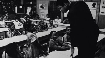 Movie still from “When We Were Kings” (1996), directed by Leon Gast – A black and white photo of a classroom of children; Medium shot, Low angle