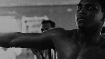 Movie still from “When We Were Kings” (1996), directed by Leon Gast – A black and white photo of a man with his arms outstreched; Close Up shot, Low angle