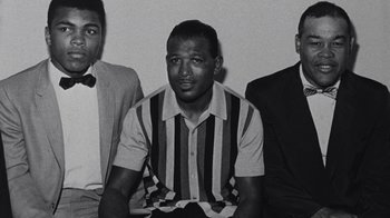 Movie still from “When We Were Kings” (1996), directed by Leon Gast – A black - and - white photo of three men sitting next to each other; Close Up shot, Low angle