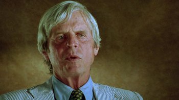 Movie still from “When We Were Kings” (1996), directed by Leon Gast – An older man wearing a striped jacket and a neck tie; Close Up shot, Low angle