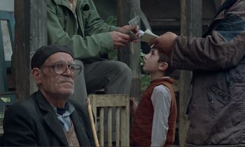 Movie still from “Where Is the Friend's House?” (1987), directed by Abbas Kiarostami – An old man sitting in front of a young boy; Medium shot, Over the shoulder angle