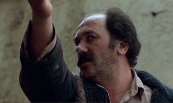 Movie still from “Where Is the Friend's House?” (1987), directed by Abbas Kiarostami – A person with a beard and mustache; Close Up shot, Low angle