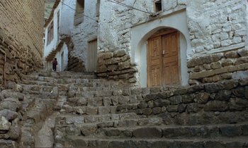 Movie still from “Where Is the Friend's House?” (1987), directed by Abbas Kiarostami – A person walking up the stairs; Extreme Wide shot, High angle