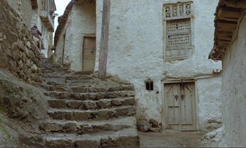 Movie still from “Where Is the Friend's House?” (1987), directed by Abbas Kiarostami – A stone staircase leading up to an old building; Extreme Wide shot, Low angle