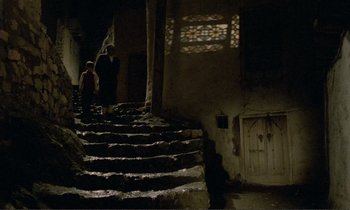 Movie still from “Where Is the Friend's House?” (1987), directed by Abbas Kiarostami – Two people walking down a set of stairs; Extreme Wide shot, High angle