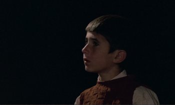 Movie still from “Where Is the Friend's House?” (1987), directed by Abbas Kiarostami – A young boy is looking into the distance; Close Up shot, Over the shoulder angle