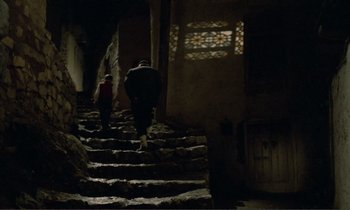 Movie still from “Where Is the Friend's House?” (1987), directed by Abbas Kiarostami – Two people walking down a set of stairs; Wide shot, Low angle