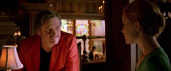 Movie still from “Where the Truth Lies” (2005), directed by Atom Egoyan – A man in a red jacket sitting in front of a window; Close Up shot, Low angle