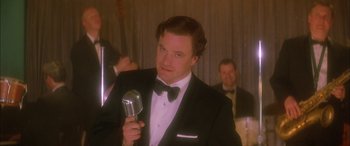 Movie still from “Where the Truth Lies” (2005), directed by Atom Egoyan – A man in a tuxedo holding up a microphone; Close Up shot, Low angle