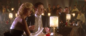 Movie still from “Where the Truth Lies” (2005), directed by Atom Egoyan – A man and a woman sitting in front of a lamp; Medium shot, Low angle