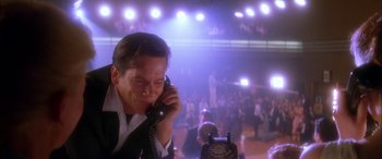 Movie still from “Where the Truth Lies” (2005), directed by Atom Egoyan – A man talking on a phone in front of an audience; Close Up shot, Low angle