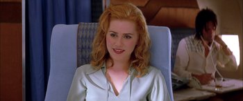 Movie still from “Where the Truth Lies” (2005), directed by Atom Egoyan – A woman sitting in a chair wearing a green shirt; Close Up shot, Over the shoulder angle