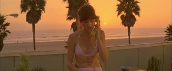 Movie still from “Where the Truth Lies” (2005), directed by Atom Egoyan – A woman talking on a phone while standing by the beach; Medium shot, High angle