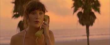 Movie still from “Where the Truth Lies” (2005), directed by Atom Egoyan – A woman talking on a phone on the beach; Close Up shot, High angle