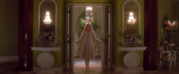 Movie still from “Where the Truth Lies” (2005), directed by Atom Egoyan – A woman in a white coat standing in front of a doorway; Wide shot, Low angle