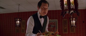 Movie still from “Where the Truth Lies” (2005), directed by Atom Egoyan – A man holding a plate of food in front of him; Close Up shot, Low angle