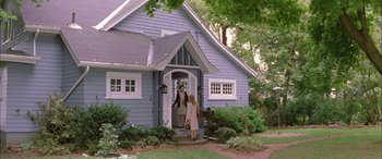 Movie still from “Where the Truth Lies” (2005), directed by Atom Egoyan – A woman and a man entering a blue house; Wide shot, Low angle