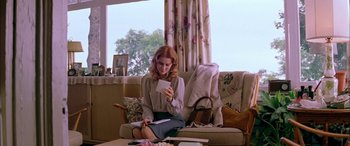 Movie still from “Where the Truth Lies” (2005), directed by Atom Egoyan – A woman sitting on a couch looking at her cell phone; Medium shot, Low angle