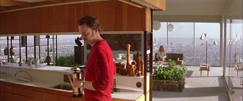 Movie still from “Where the Truth Lies” (2005), directed by Atom Egoyan – A man in a red shirt is in a kitchen; Medium shot, Low angle