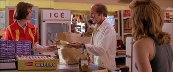 Movie still from “Where the Truth Lies” (2005), directed by Atom Egoyan – A man holding a sandwich in his hands; Medium shot, Over the shoulder angle
