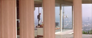Movie still from “Where the Truth Lies” (2005), directed by Atom Egoyan – A man standing in front of a large window; Extreme Wide shot, Over the shoulder angle
