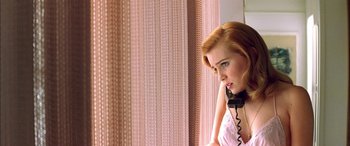 Movie still from “Where the Truth Lies” (2005), directed by Atom Egoyan – A woman sitting in front of a window holding a phone to her ear; Close Up shot, Low angle