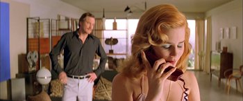 Movie still from “Where the Truth Lies” (2005), directed by Atom Egoyan – A man and a woman standing next to each other on a cell phone; Medium shot, Low angle