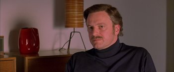 Movie still from “Where the Truth Lies” (2005), directed by Atom Egoyan – A person with a beard and mustache; Close Up shot, Low angle