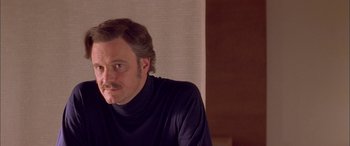 Movie still from “Where the Truth Lies” (2005), directed by Atom Egoyan – A person sitting in a room; Close Up shot, Over the shoulder angle