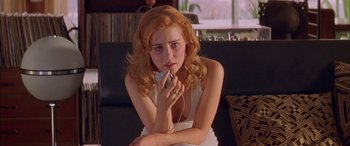 Movie still from “Where the Truth Lies” (2005), directed by Atom Egoyan – A woman sitting on a couch holding a cell phone to her ear; Close Up shot, Low angle