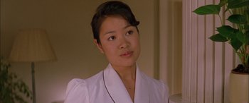 Movie still from “Where the Truth Lies” (2005), directed by Atom Egoyan – A woman in a white shirt is posing for a picture; Close Up shot, Over the shoulder angle