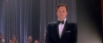 Movie still from “Where the Truth Lies” (2005), directed by Atom Egoyan – A man in a tuxedo standing in front of a crowd; Close Up shot, Low angle