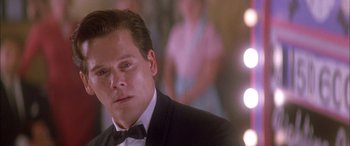 Movie still from “Where the Truth Lies” (2005), directed by Atom Egoyan – A person wearing a suit and a bow tie; Close Up shot, Over the shoulder angle