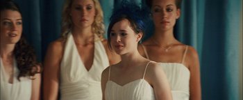 Movie still from “Whip It” (2009), directed by Drew Barrymore – A woman in a white dress with two other women; Close Up shot, Over the shoulder angle