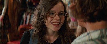 Movie still from “Whip It” (2009), directed by Drew Barrymore – A person wearing glasses and smiling; Close Up shot, Over the shoulder angle