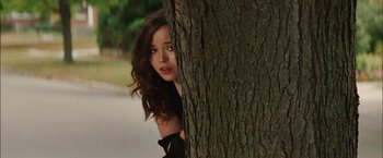 Movie still from “Whip It” (2009), directed by Drew Barrymore – A beautiful young woman leaning against a tree; Medium shot, Over the shoulder angle