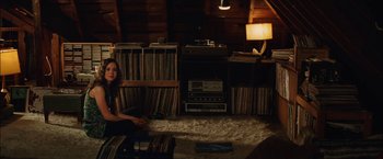 Movie still from “Whip It” (2009), directed by Drew Barrymore – A woman sitting on the floor next to a pile of records; Wide shot, High angle