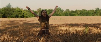 Movie still from “Whip It” (2009), directed by Drew Barrymore – A woman in a field with her hands raised; Medium shot, Low angle