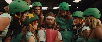 Movie still from “Whip It” (2009), directed by Drew Barrymore – A group of people wearing green helmets and a man with a beard; Medium shot, Low angle