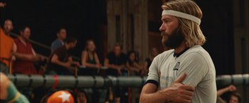 Movie still from “Whip It” (2009), directed by Drew Barrymore – A man with a beard is standing in front of a group of people; Close Up shot, Low angle
