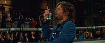 Movie still from “Whip It” (2009), directed by Drew Barrymore – A man in a blue jacket holding a microphone up to his face; Close Up shot, Low angle