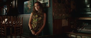 Movie still from “Whip It” (2009), directed by Drew Barrymore – A woman standing in front of a wall with her arms crossed; Medium shot, Over the shoulder angle