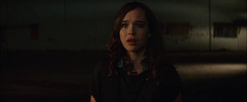 Movie still from “Whip It” (2009), directed by Drew Barrymore – A woman with long brown curly hair wearing a black shirt; Close Up shot, Over the shoulder angle