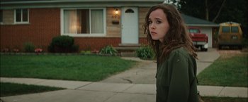 Movie still from “Whip It” (2009), directed by Drew Barrymore – A young woman standing in front of a house; Medium shot, Over the shoulder angle