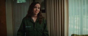 Movie still from “Whip It” (2009), directed by Drew Barrymore – A woman in a green shirt is standing in a room; Medium shot, Over the shoulder angle