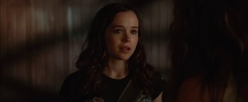 Movie still from “Whip It” (2009), directed by Drew Barrymore – A woman with long brown hair wearing a black t - shirt; Close Up shot, Over the shoulder angle