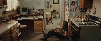 Movie still from “Whip It” (2009), directed by Drew Barrymore – A woman sitting on the floor eating food; Wide shot, Over the shoulder angle