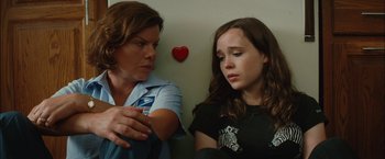 Movie still from “Whip It” (2009), directed by Drew Barrymore – A woman and a girl sitting next to each other on a wall; Medium shot, Over the shoulder angle