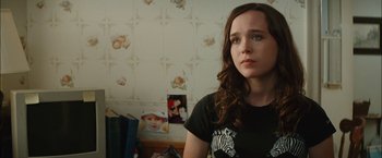 Movie still from “Whip It” (2009), directed by Drew Barrymore – A young woman in a black shirt is standing in front of a wall; Close Up shot, Over the shoulder angle