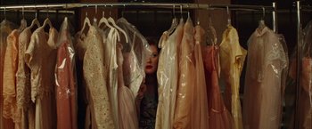 Movie still from “Whip It” (2009), directed by Drew Barrymore – A woman looking through a closet full of dresses; Medium shot, Over the shoulder angle